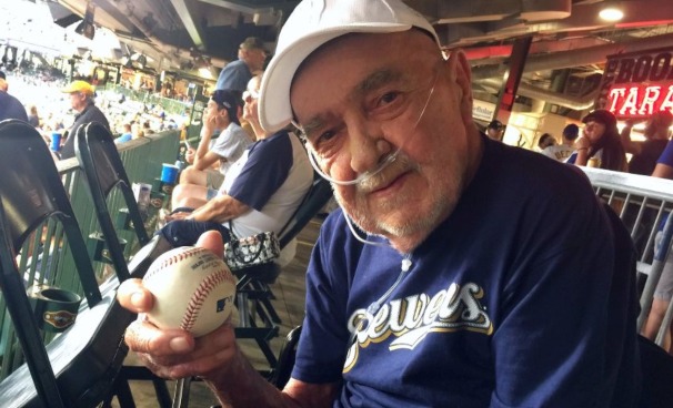 Hospice patient Russell holds the game ball he received from the Milwaukee Brewers