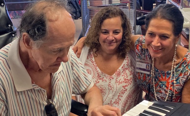 Patient David Laessig plays for music therapy intern Monica Bonasso and Volunteer Services Manager Gayle Stevens