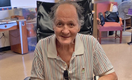 David Laessig, a hospice patient with Parkinson's disease, smiles with his keyboard